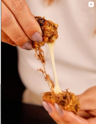 Close em bolinho de carne com queijo puxando