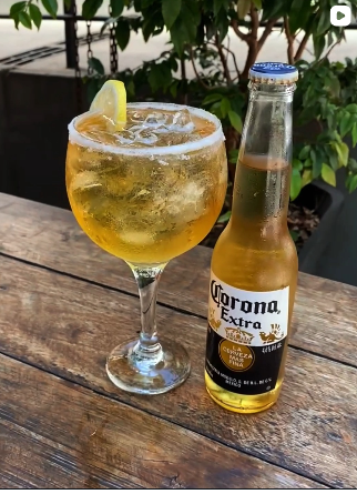 Drink gelado com cerveja servido na mesa de madeira